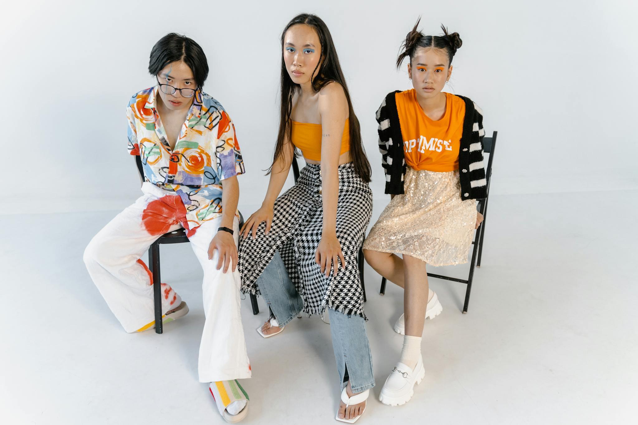 Three young models posing in vibrant urban fashion for a studio photoshoot.